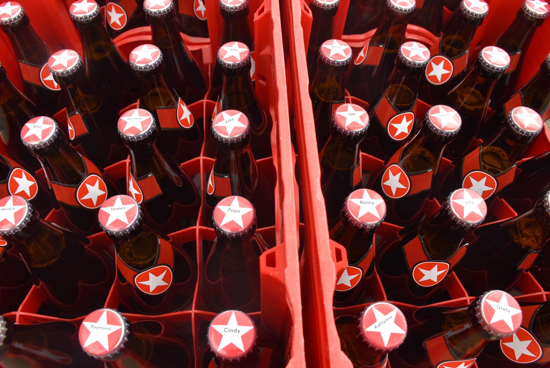 Zwei Sternburg Bierkästen nebeneinander, die Kronkorken der Flaschen sind mit individuellen Namen bedruckt.