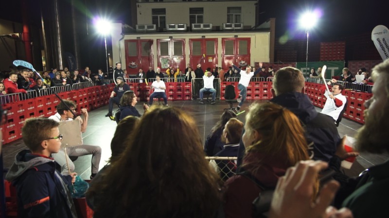 Zuschauer beobachten eine nächtliche Outdoor-Veranstaltung in einer Arena.