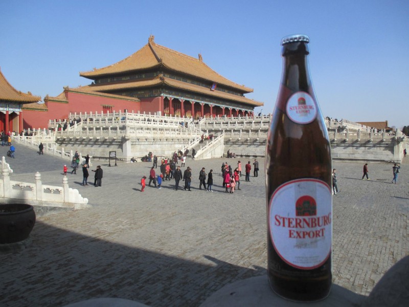 Eine Flasche Sternburg Export steht im Vordergrund vor dem Himmelstempel in Peking.